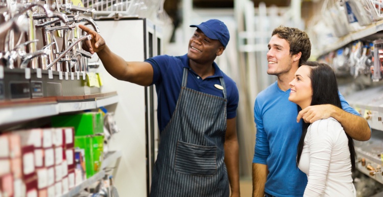 Employee shows customers products in a shelf