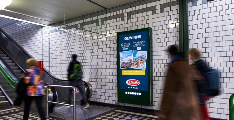 Foto: Große digitale Bildschirmstele an einer U-Bahn-Rolltreppe; copyright:...