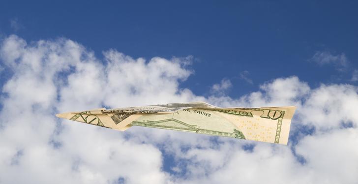 A dollar note as a paper airplane flying through the cloudy sky...