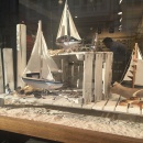 Small sailboats and glasses on sand in a shop window...