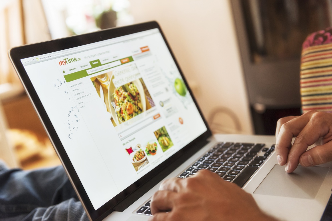 Photo: Person surfing on a laptop at the online supermarket myTime.de;...