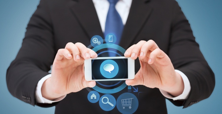 Foto: Geschäftsmann hält Smartphone mit Icons für Chat, Shopping,...