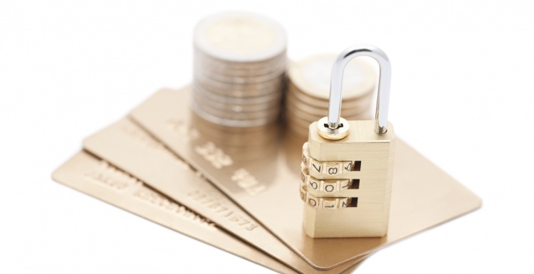 Credit cards and coins with a combination lock; copyright: panthermedia.net /...