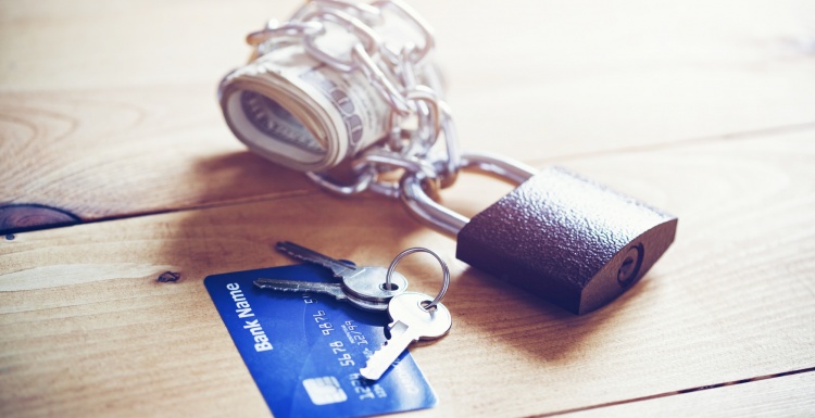 Banknotes secured by a lock and a credit card with keys; copyright:...