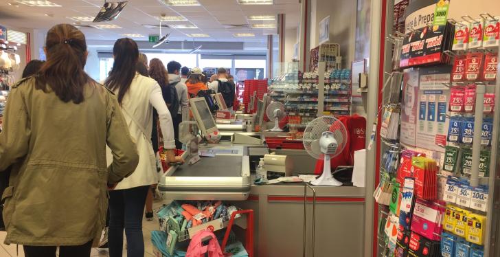 Customers waiting in a long line in a store at the checkout; copyright:...