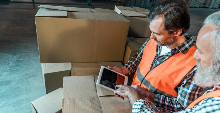 Two men working in logistics using a tablet