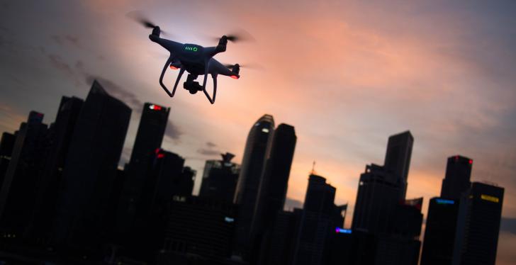A drone in front of a dark city skyline