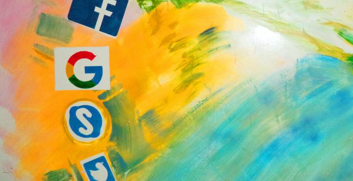 The icons of Facebook, Google, Skype and Twitter on a colorful background;...