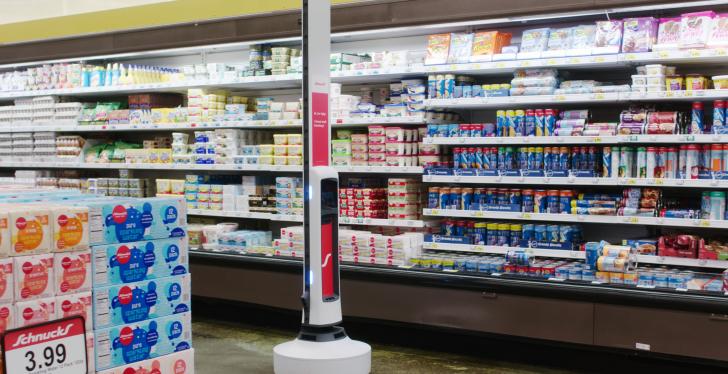 Tally the robot in front of the refrigerated shelf in a Schnuck Market...