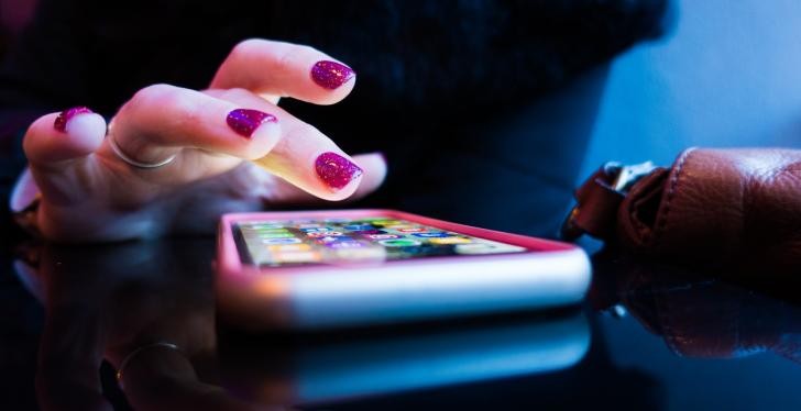 A person with colourful nails using a smartphone; Copyright: Rob...