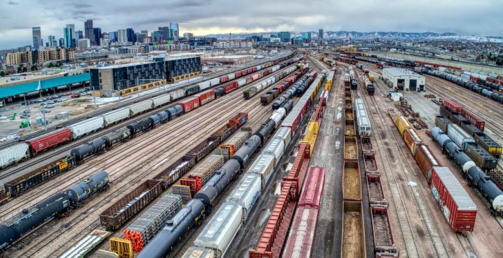 Many tracks with wagons of container trains at a big station in a city...