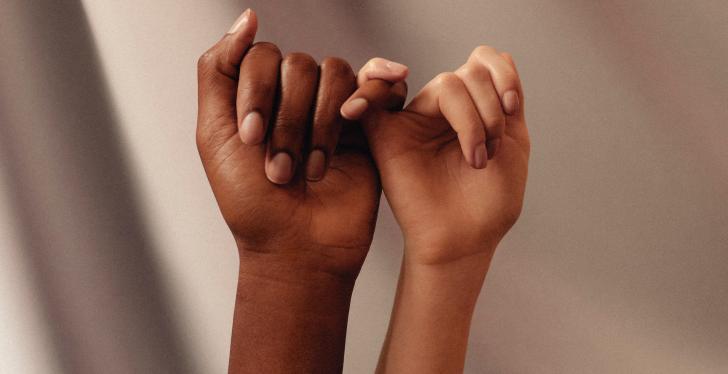 Zwei Hände mit unterschiedlichen Hautfarben berühren sich...