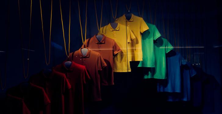 Mens shirts in different colors hanging from a ceiling in the dark; copyright:...