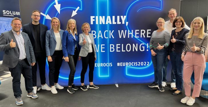 The EuroCIS 2022 team in front of a wall with the inscription Finally back...