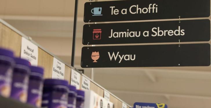 Three signs with Welsh language on them in a store