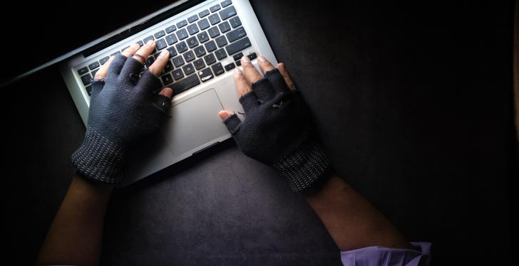 Two hands with gloves using a laptop