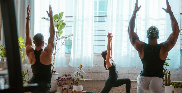 Three people doing yoga in a large room