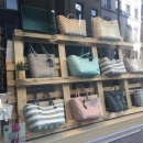 Shop window decoration with a wooden pallet with bags on it...