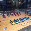 Colorful ladies shoes in a shop window on a wooden table...