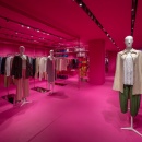 Mannequins and clothes presented inside a pink colored store...
