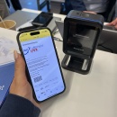 Smartphone with order confirmation and barcode is held in front of a stationary...