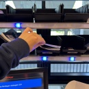 Person takes inserts from a shelf compartment with blue lighting to prepare the...