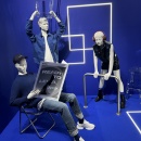 3 mannequins in a blue setting striking bold poses: one is lifting a chair,...