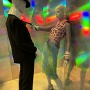 Two mannequins bathed in disco-style lighting. The female-looking mannequin is...
