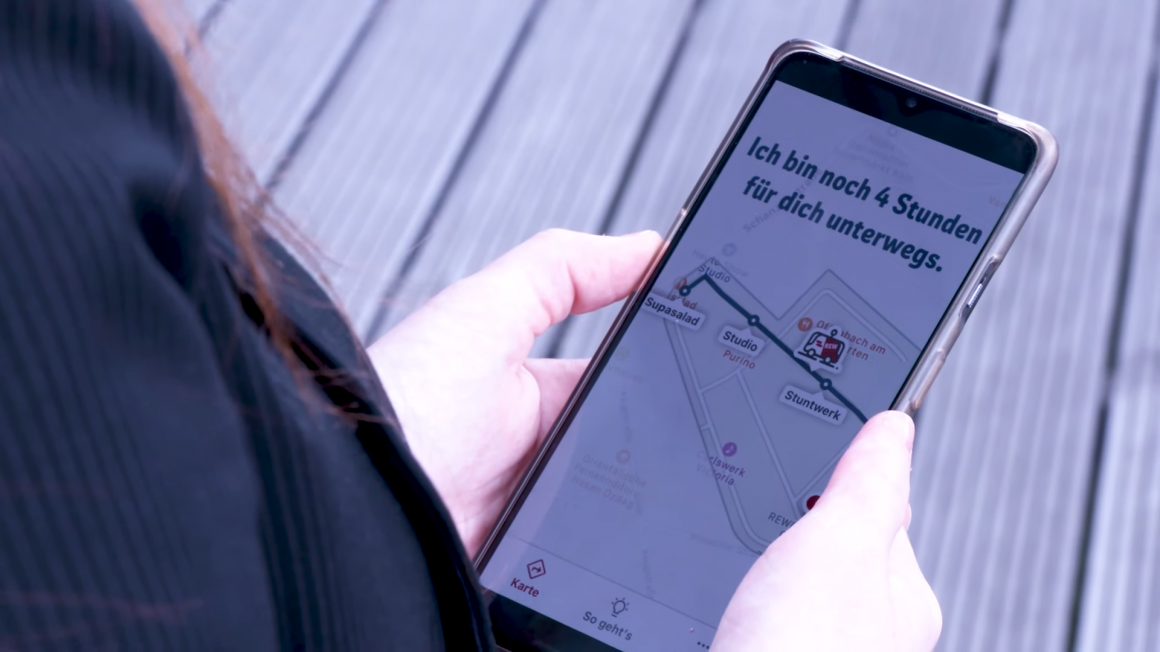A smartphone held in the hand on which a route is displayed how long the...