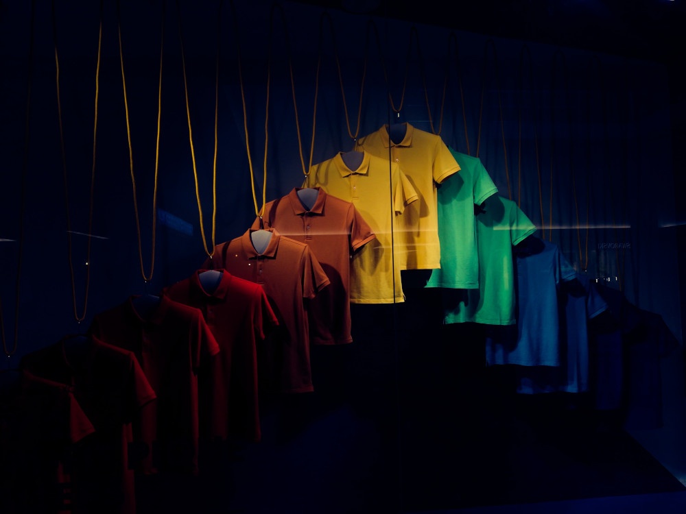 Mens shirts in different colors hanging from a ceiling in the dark...