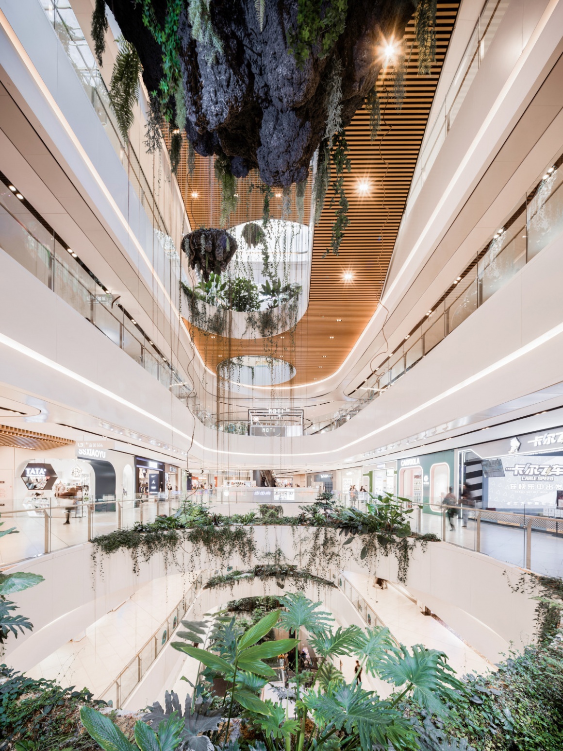 A shopping mall with several stories and hanging plants; copyright: Chill Shine...