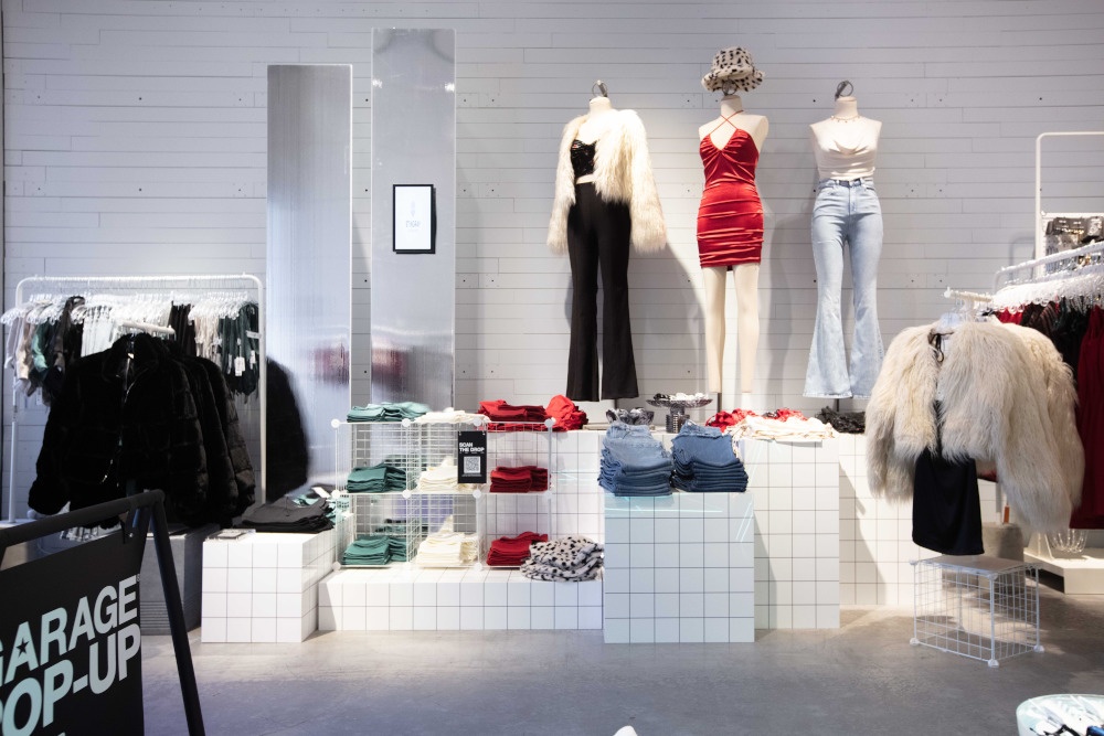 A modern design fashion pop-up store with mannequins standing on white tiled...