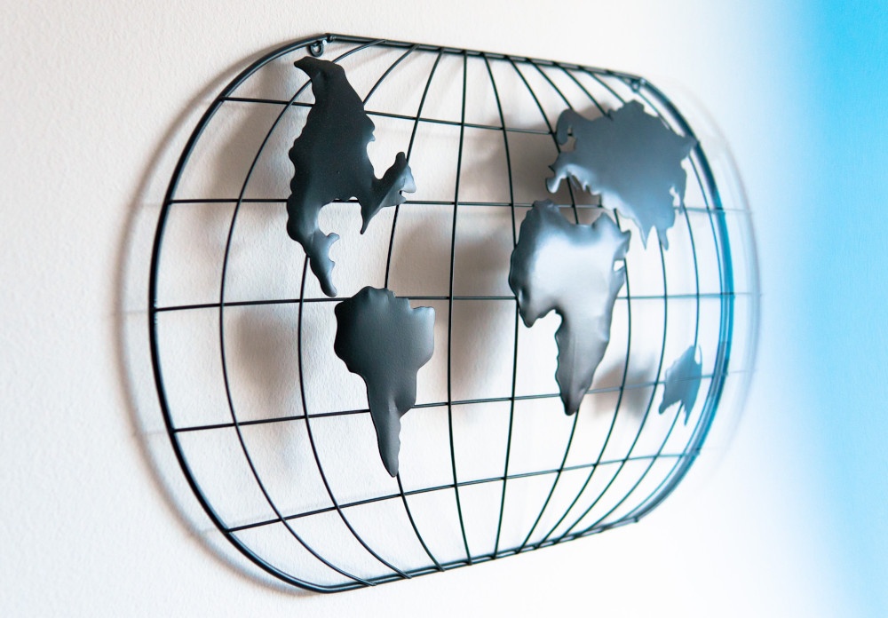 A simple stylized world map on a longitude and latitude grid, all steel;...