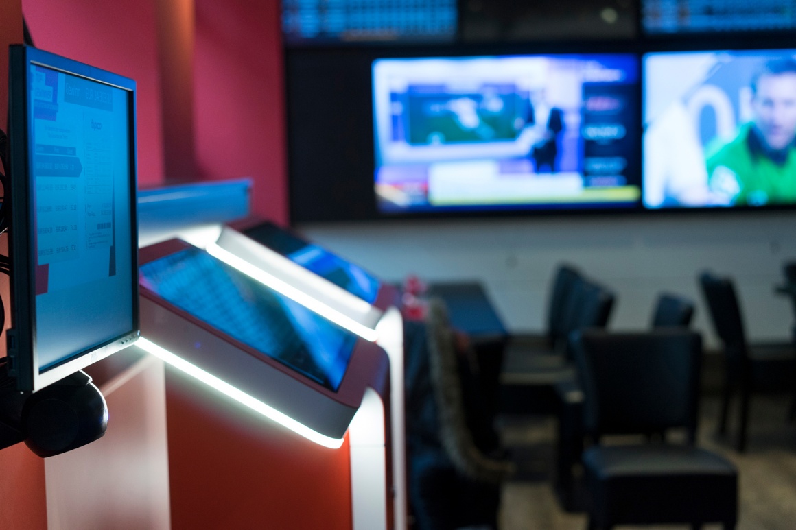 Multiple screens and tables with chairs in a large room...