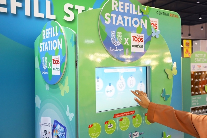 A person using the touchscreen of a refill station