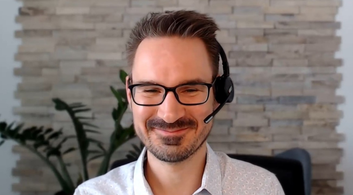 A man with headphones and microphone at a webtalk