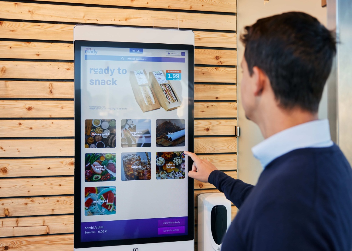 Man ordering groceries at a screen.