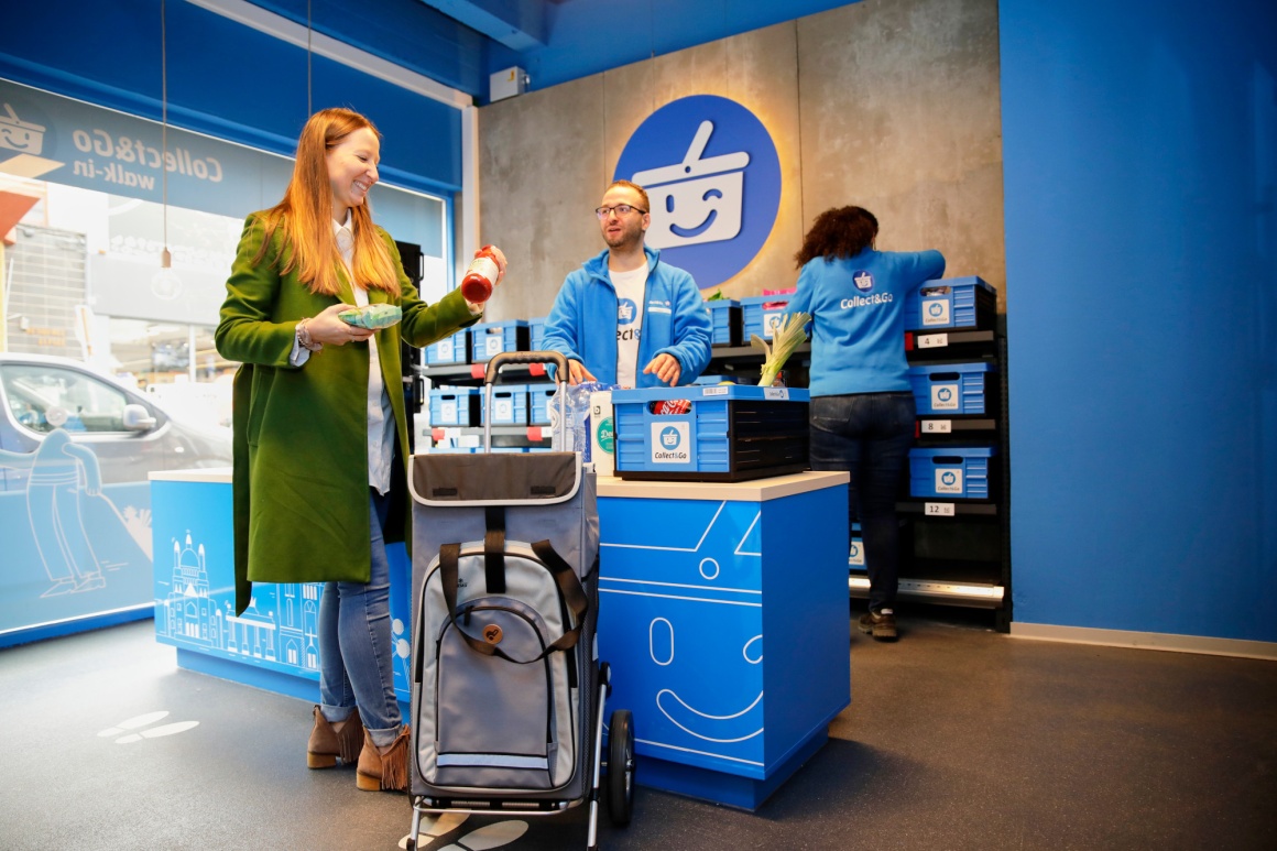 A customer puts goods into a shopping bag at a checkout counter...