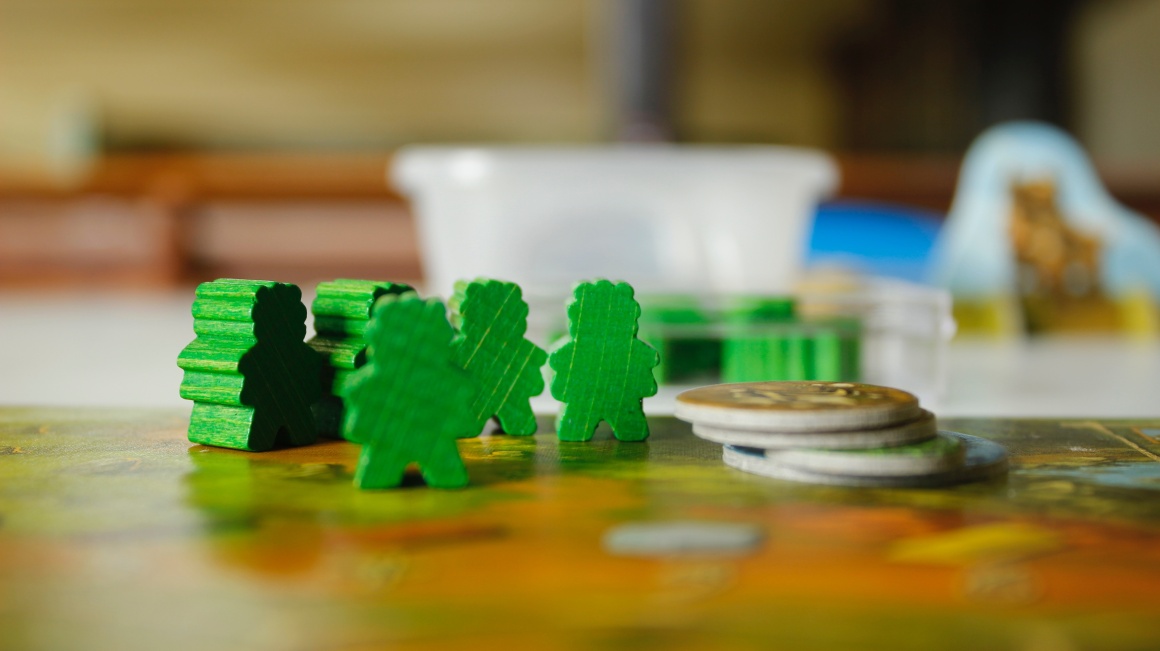 Green figures and coins on a game board