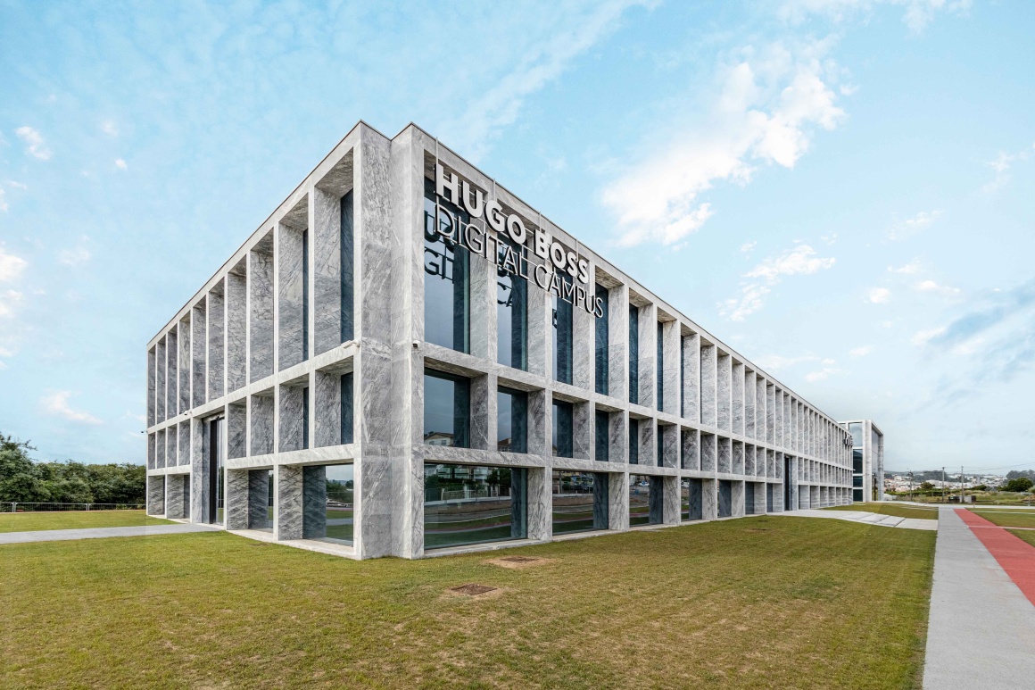 Exterior view of a large building with the sign Hugo Boss Digital Campus...