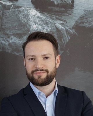 Man with dark hair and beard looks friendly into the camera...