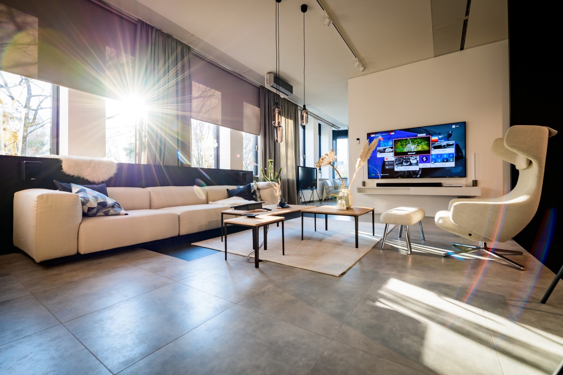 A showroom furnished as a living room with a sofa set and television...