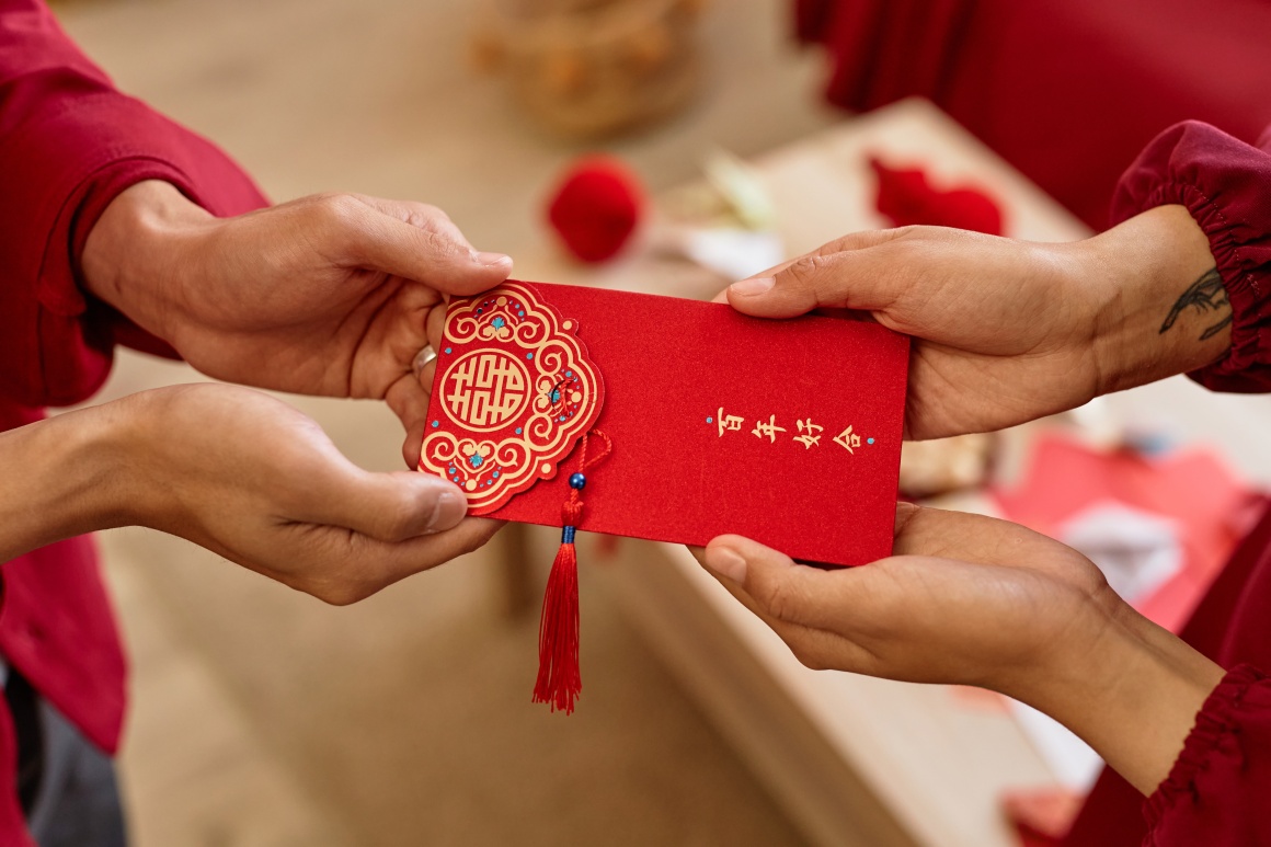 A red envelope is handed from one person to the other...