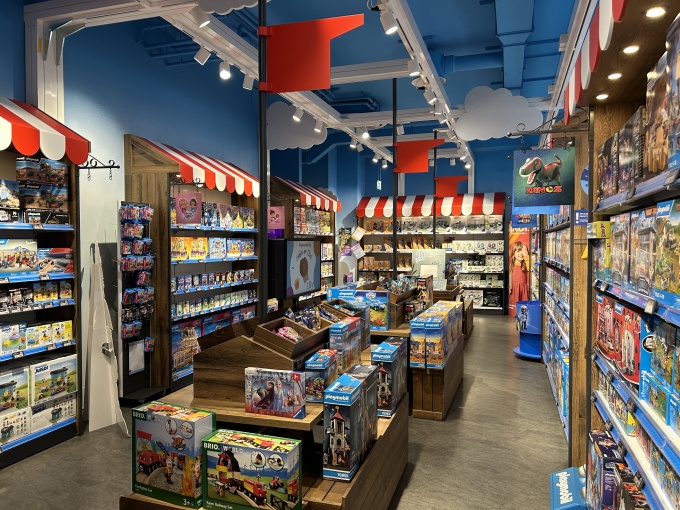 The sales area is designed like a colorful market: red and white awnings, small...
