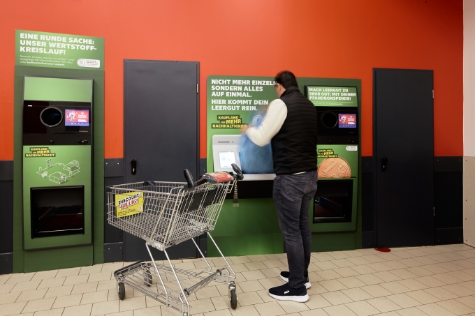Man deposits collected empty bottles and cans at a Kaufland reverse vending...