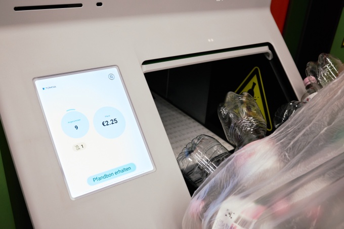 Close-up of a reverse vending machine screen showing 9 accepted bottles and...