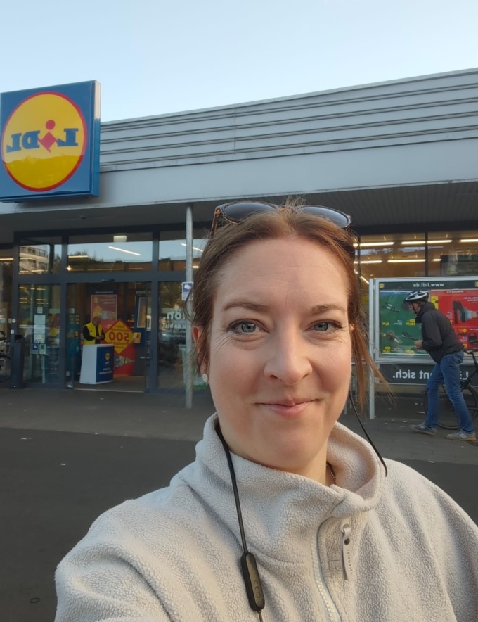 Frau macht Selfie vor LIDL-Filiale