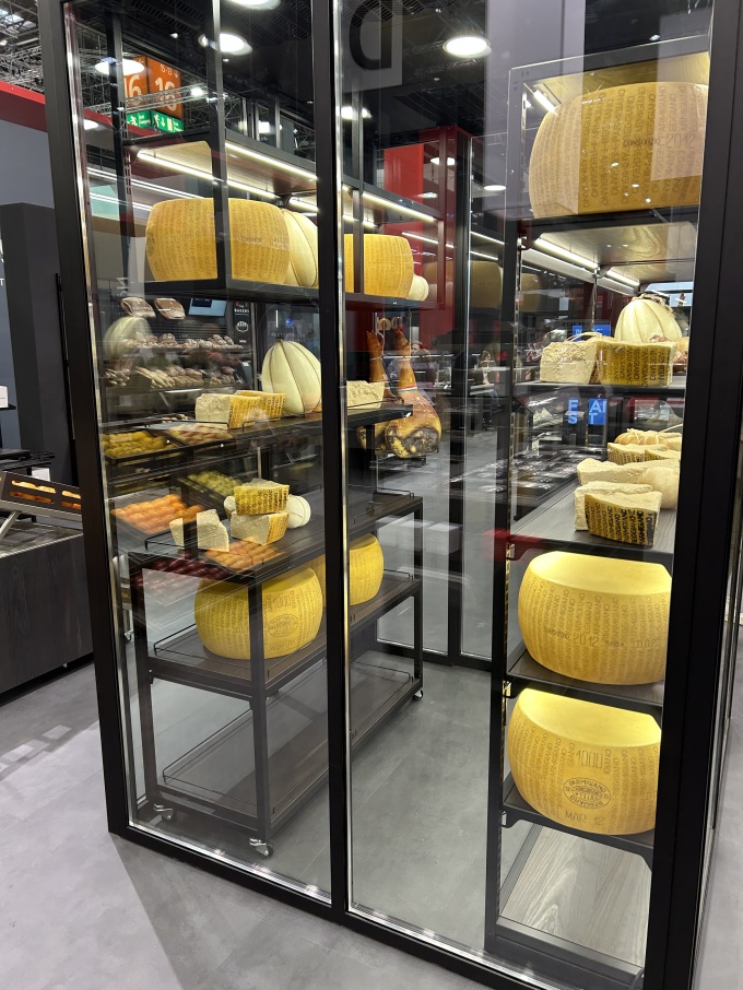 Displaying cheese products behind glass.