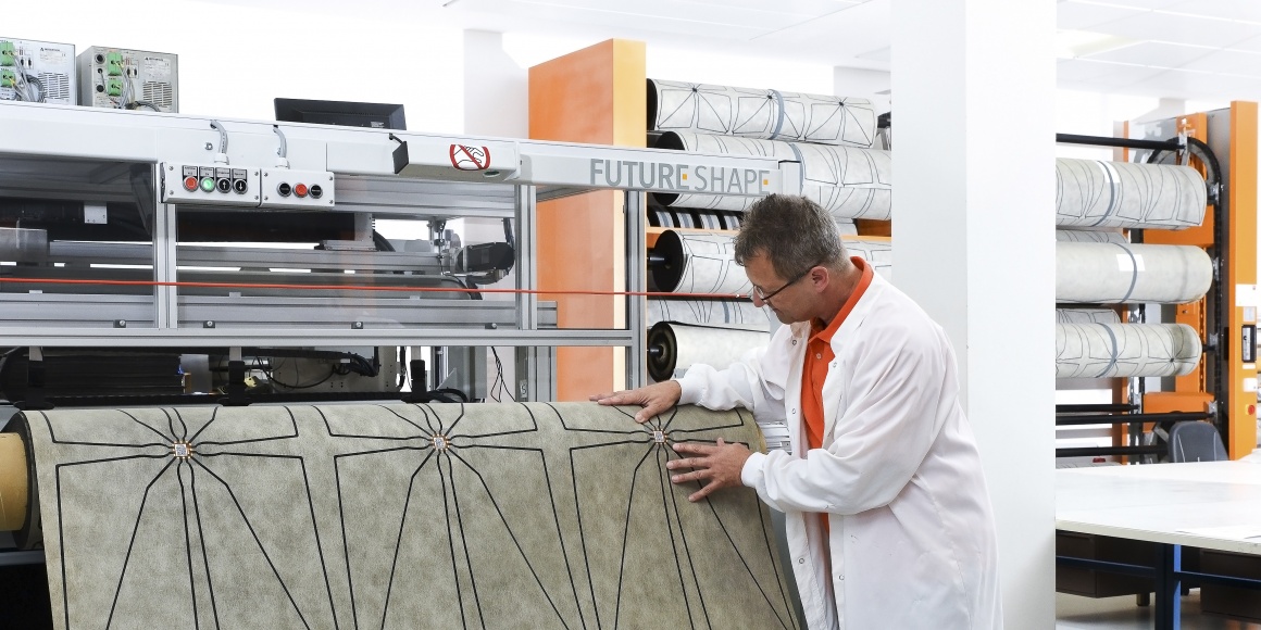 Photo: Engineer examining the underlay for the SensFloor System. Source:...