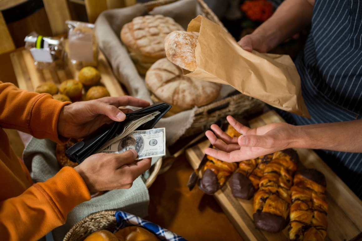 Photo: Person paying in cash in a bakery; copyright: panthermedia.net /...